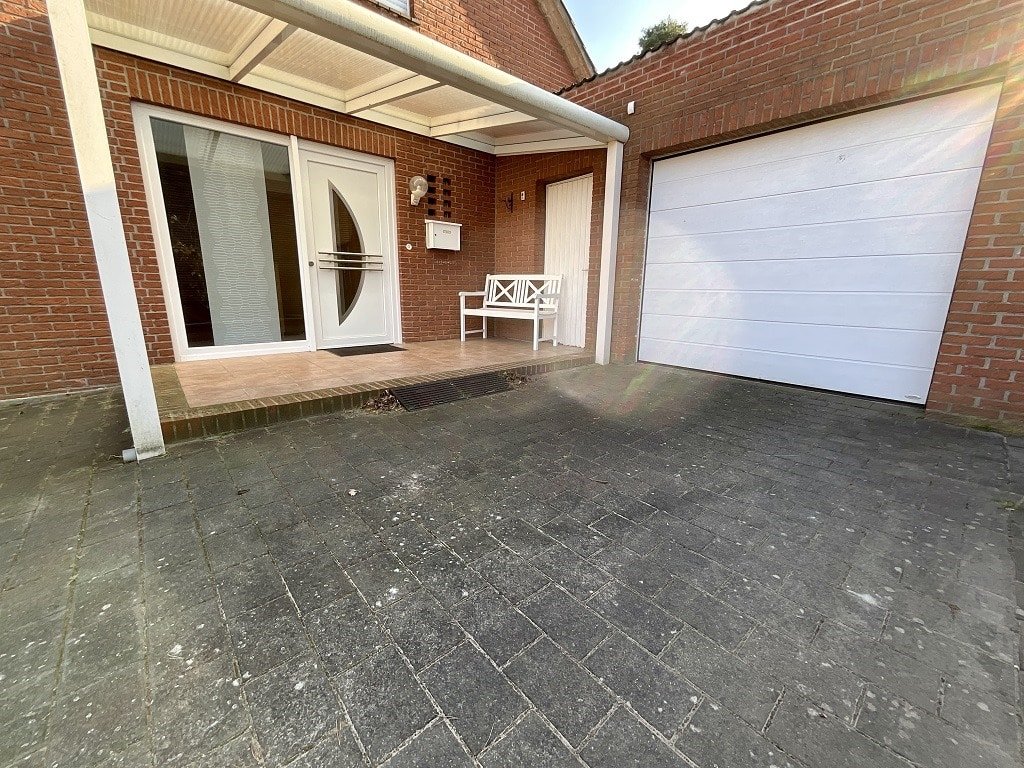 Garage mit elektrischem Sektionaltor. Überdachter Eingangsbereich.
