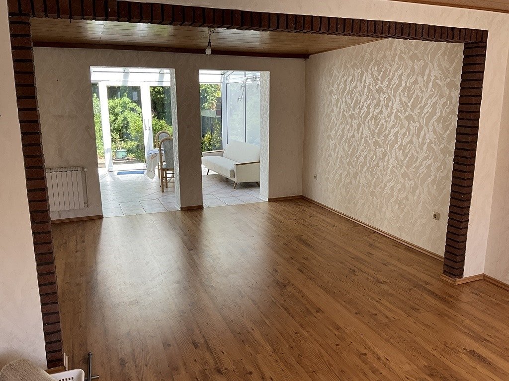Wohnzimmer mit Durchgang zum Wintergarten