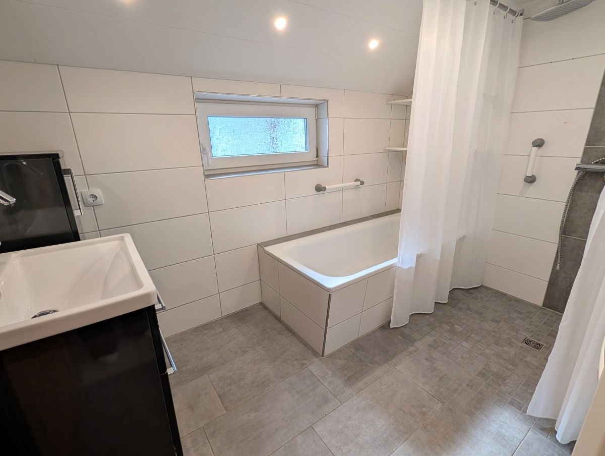 Bad mit ebenerdiger Dusche und Wanne im Erdgeschoss