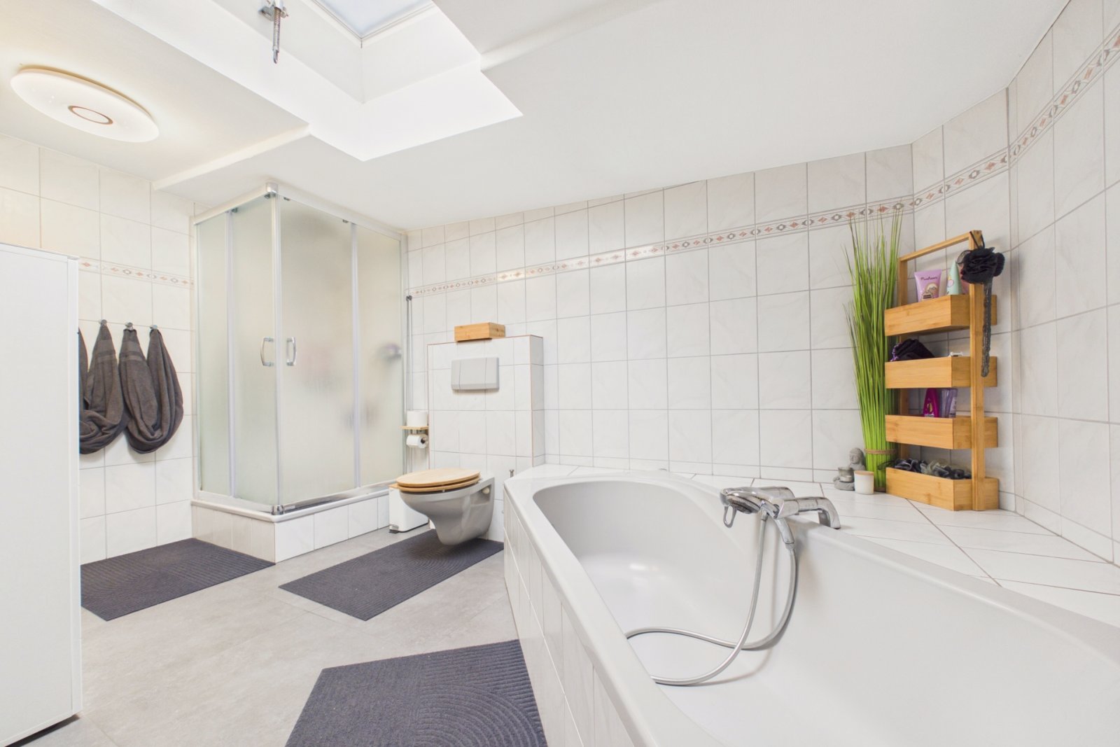 Badezimmer mit Badewanne, Dusche und Dachfenster