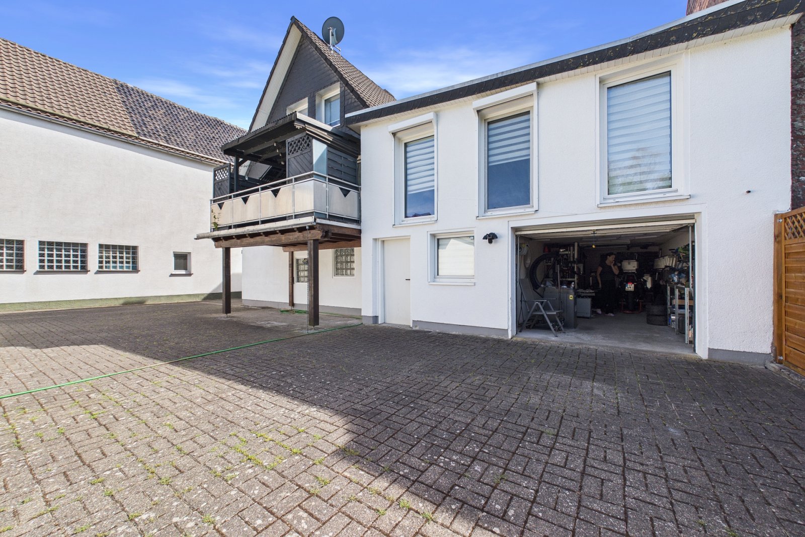 Rückansicht mit überdachter Terrasse und Garage