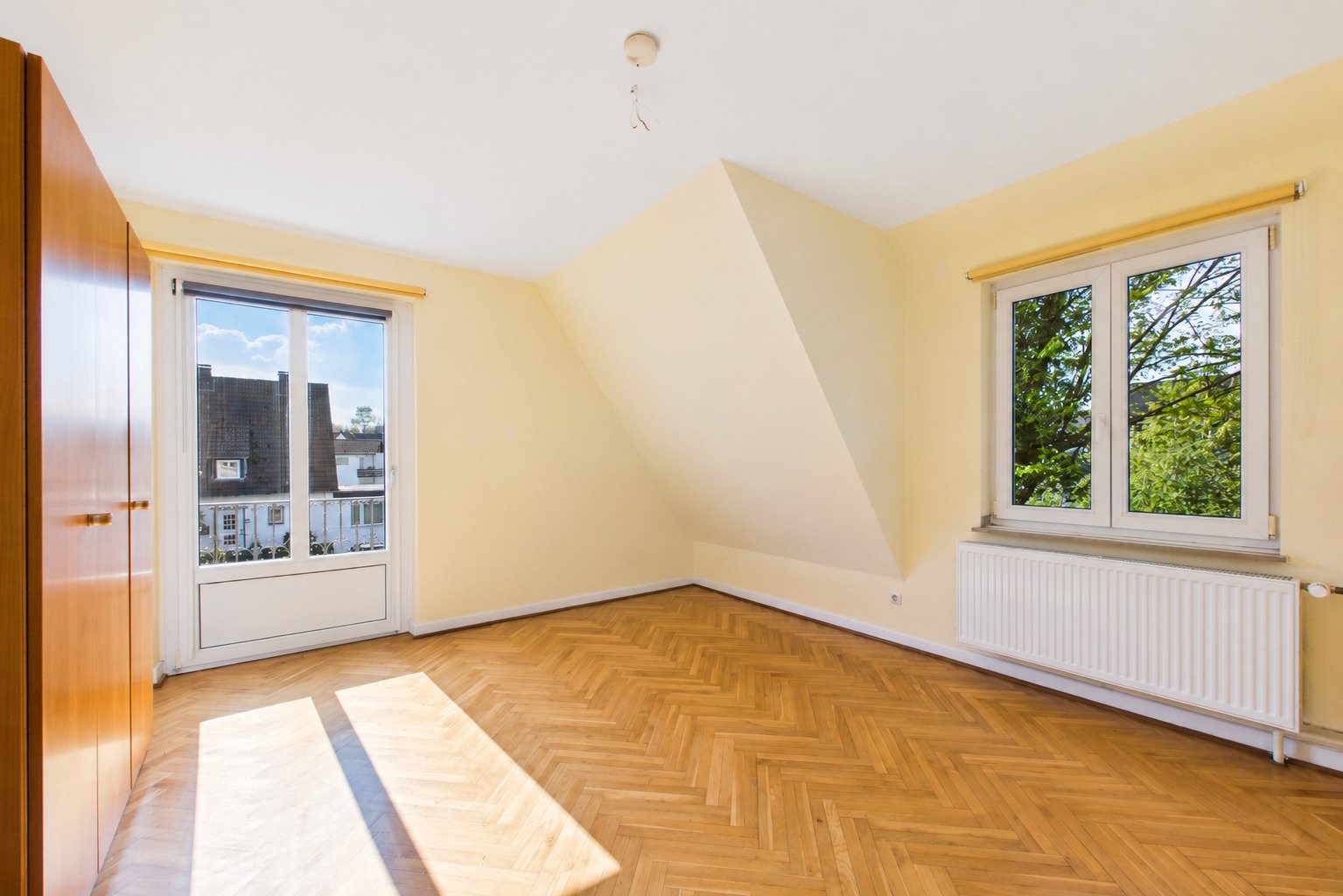 Helles Zimmer mit Parkettboden und Dachschräge Helles Zimmer mit Parkettboden und Dachschräge