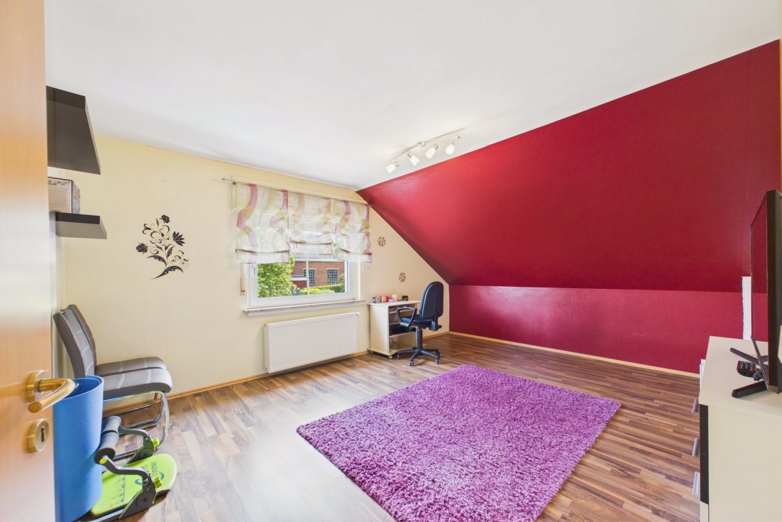 Zimmer mit farbiger Akzentwand und Laminatboden Zimmer mit farbiger Akzentwand und Laminatboden