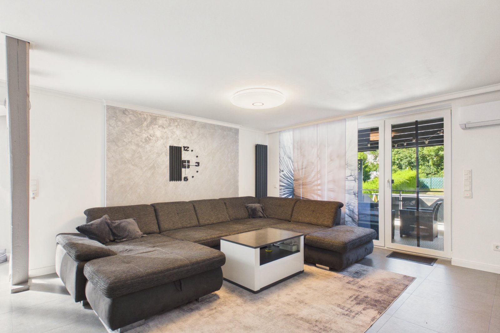 Wohnzimmer mit großer Couch und Terrassenzugang