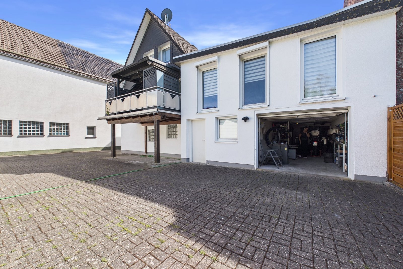 Rückansicht mit überdachter Terrasse und Garage