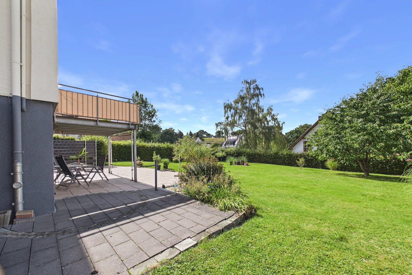 Überdachte Terrasse mit Blick in den weitläufigen Garten Überdachte Terrasse mit Blick in den weitläufigen Garten